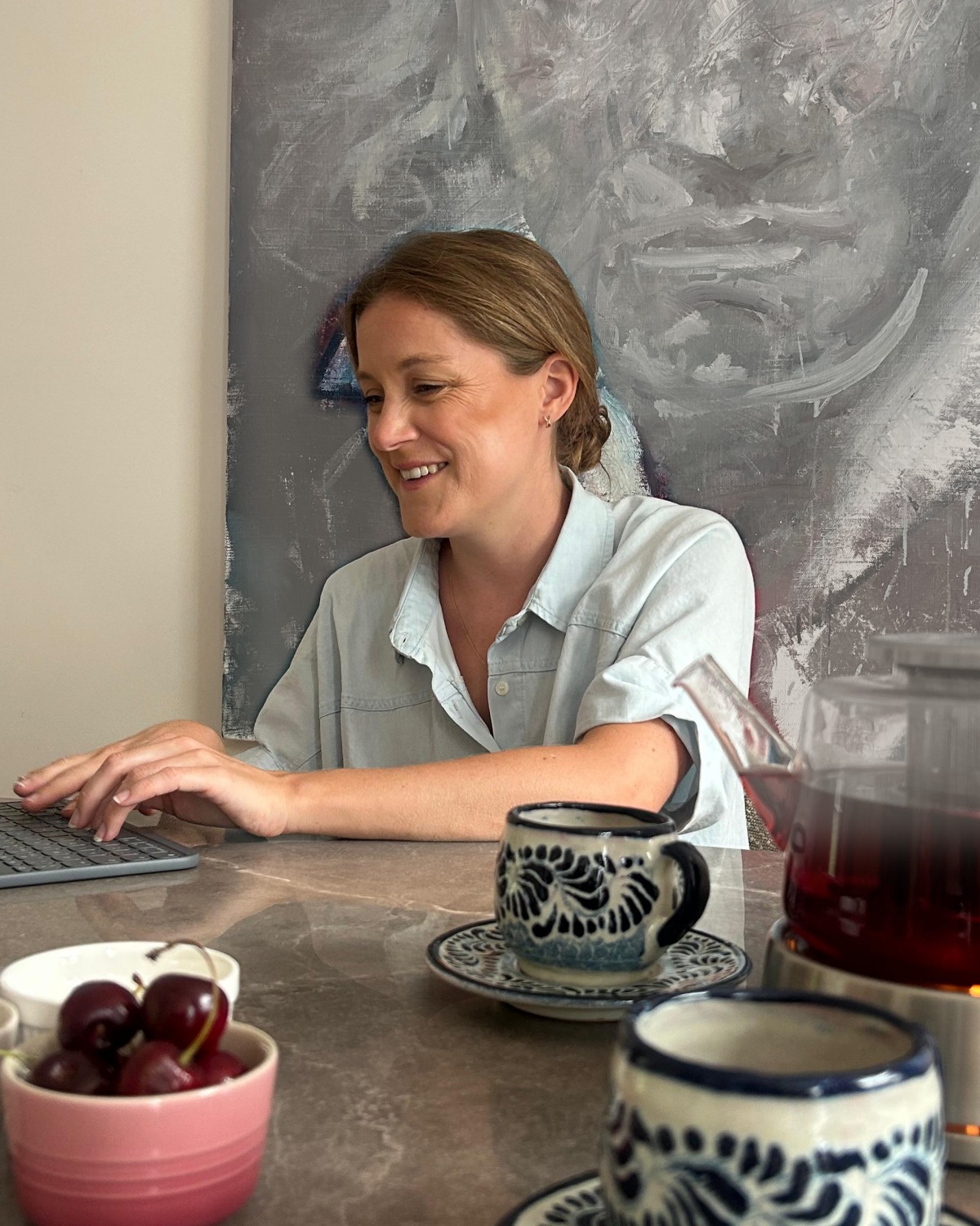 Louise Sinnerton working at her laptop with a pot of tea